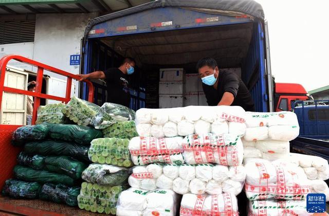 在安徽省蚌埠市海吉星农产品批发市场,商户将蔬菜装箱准备配送